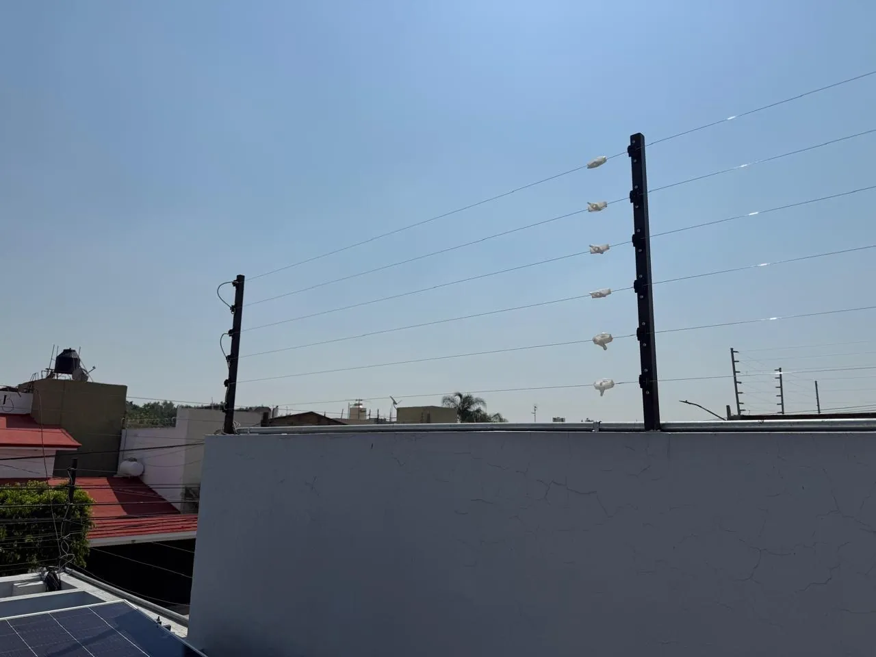 Cerca electrificada instalada sobre la barda de una casa