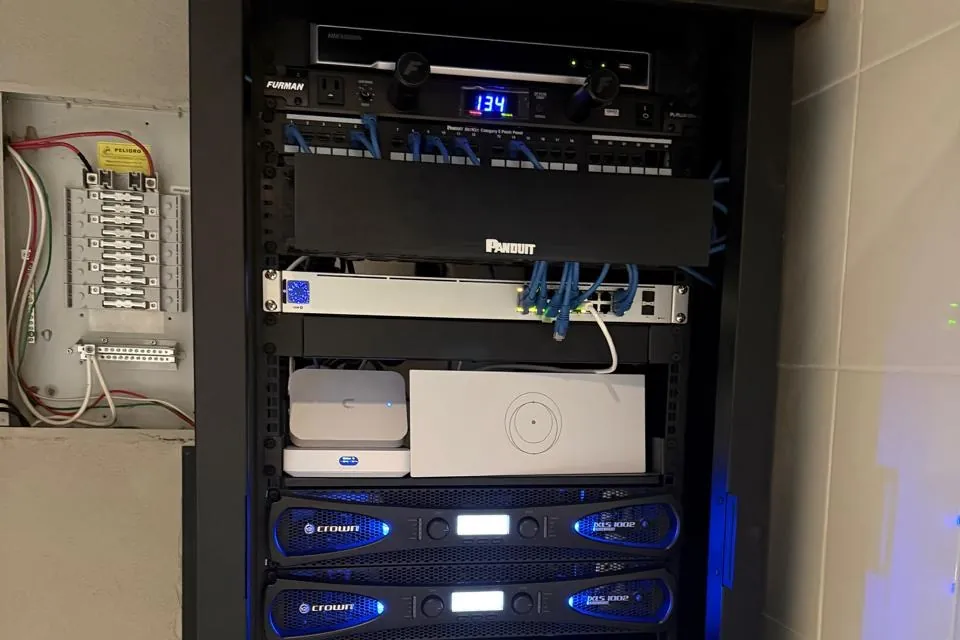 Rack de red con panel de parcheo, switch y equipos ordenados